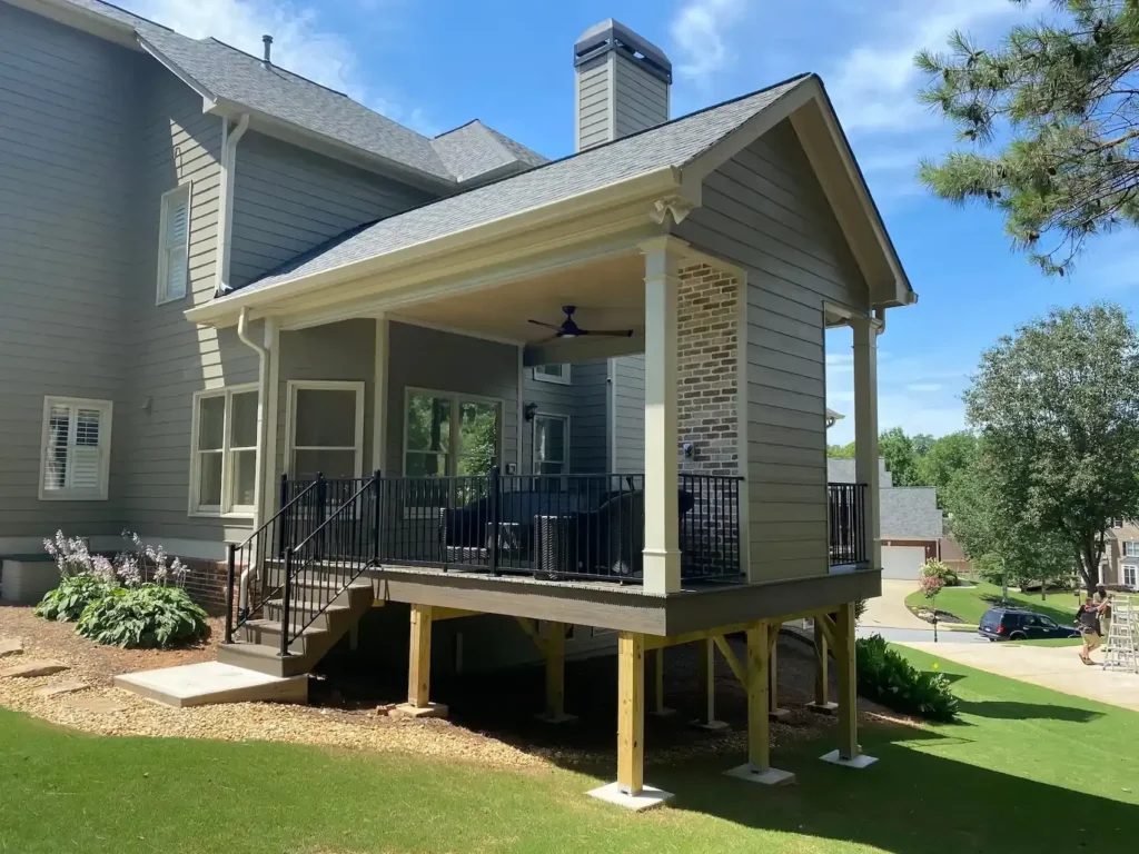 Rear view of a gray home featuring a custom-built elevated screened-in porch.