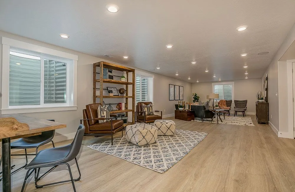 Spacious living room with leather chairs, area rug, and modern shelving.