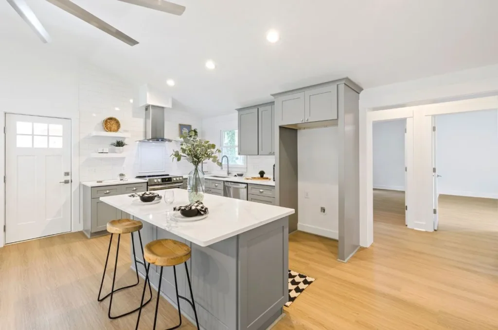 Modern open-concept kitchen with grey cabinetry and a white quartz island.