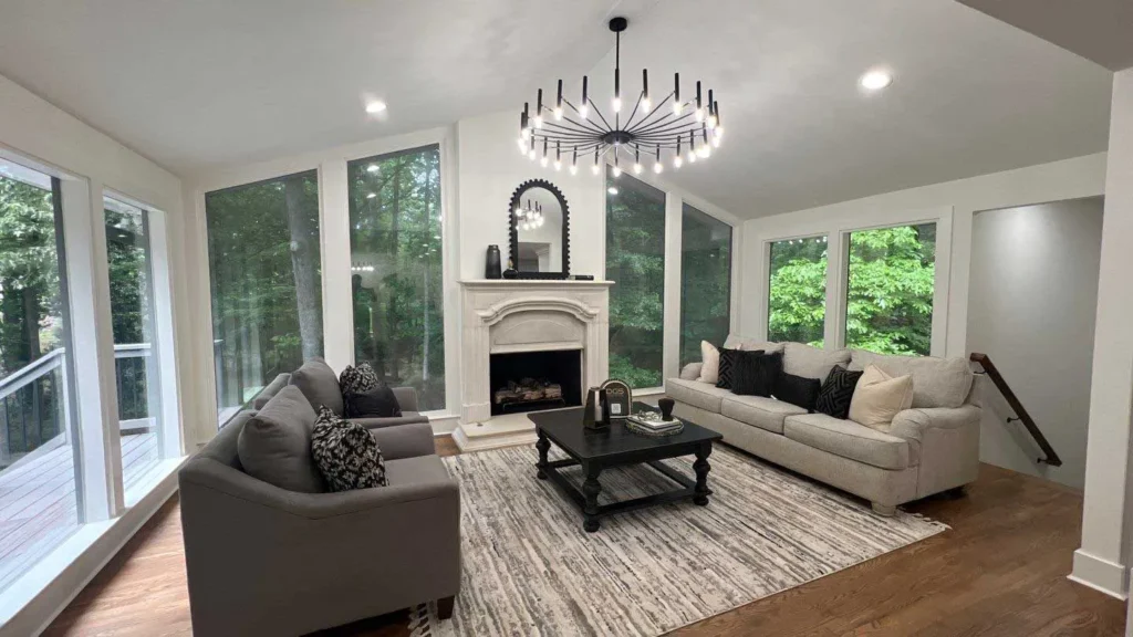 Spacious living room with a stone fireplace, large windows, and modern furniture.