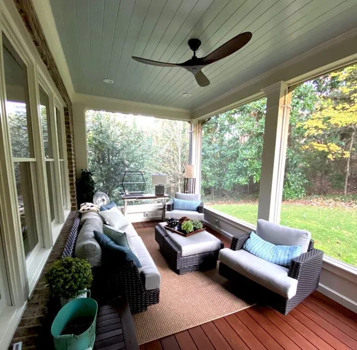 Luxurious covered deck featuring comfortable patio seating and a ceiling fan.